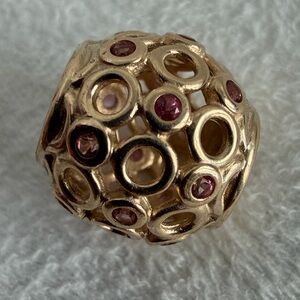Retired Pandora 14kt yellow gold "Celtic Circles" charm with pink topaz stones.